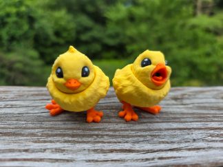 Flexi chick, a 3D printed articulated chick toy, posed on a desk.